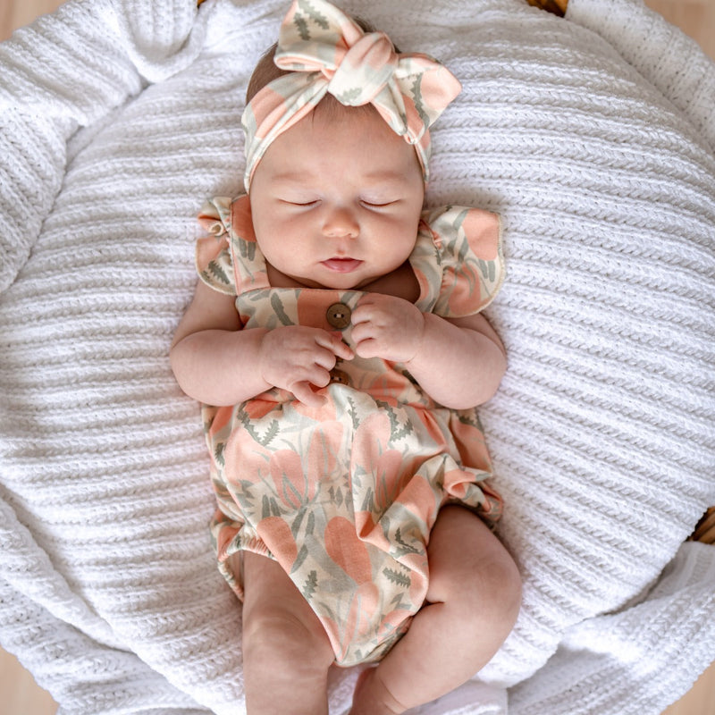 Baby romper with matching bow. Australian designed with banksia floral print by boho baby brand